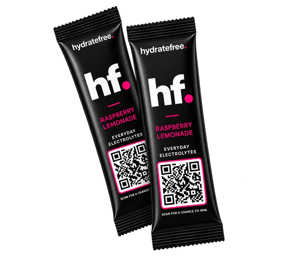 Two black HydrateFree everyday electrolyte stick packs with the pink hf. logo and a QR code